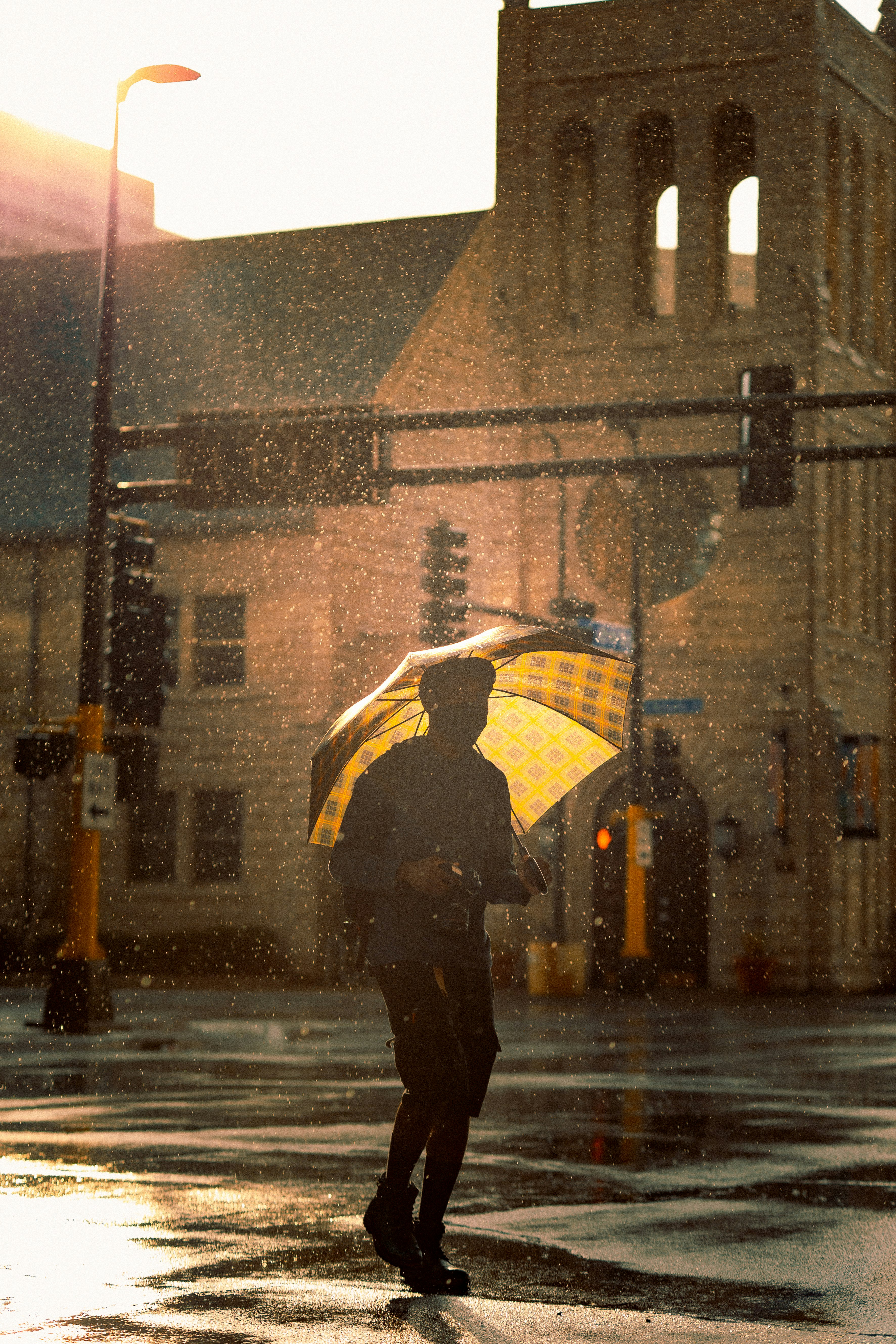 person in black jacket holding umbrella walking on street during rain